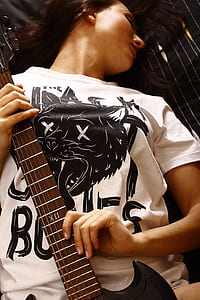 woman holding brown and black electric guitar thumbnail