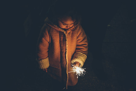 toddler holding firework during nighttime thumbnail