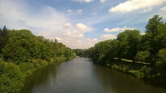 body of water between green forests thumbnail