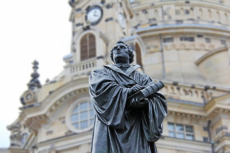 man wearing academic shirt and holding book statue thumbnail