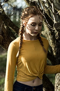 photo of woman standing beside leafless tree thumbnail
