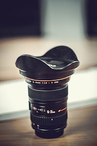 black camera lens on brown wooden surface thumbnail
