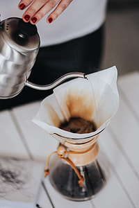Woman pouring water in Chemex filter coffee maker thumbnail