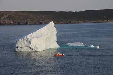 white and red ship near white rock formation thumbnail