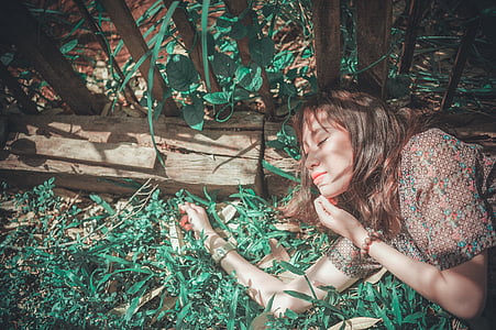 woman wearing brown floral shirt leaning on wooden fence thumbnail