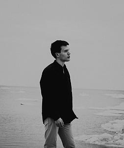 grayscale photography of man wearing dress shirt beside body of water thumbnail