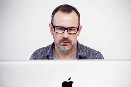 man in black button-top in front of iMac thumbnail