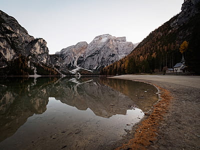 photo of mountains reflection on body of water during sunset thumbnail