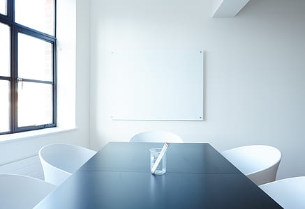 clear glass vase in middle of black wooden table inside white-painted room thumbnail