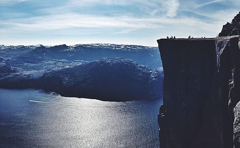 mountain cliff and body of water during daytime thumbnail
