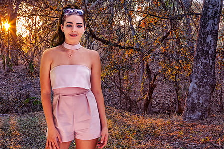 woman in gray romper shorts standing on forest thumbnail