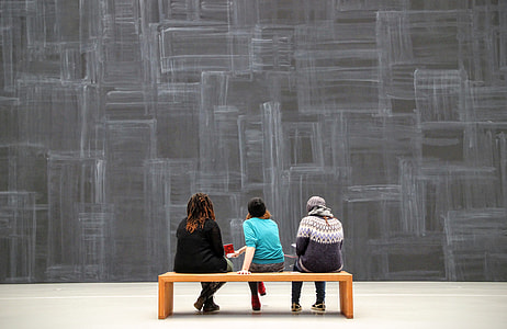 three person sitting on brown wooden bench thumbnail