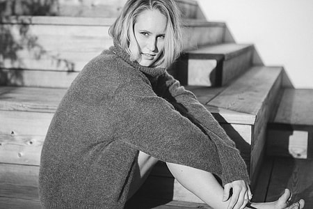 grayscale photo of a woman sitting on stairs thumbnail