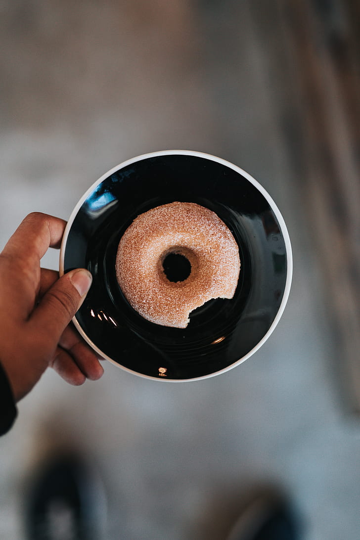 person holding plate with doughnut