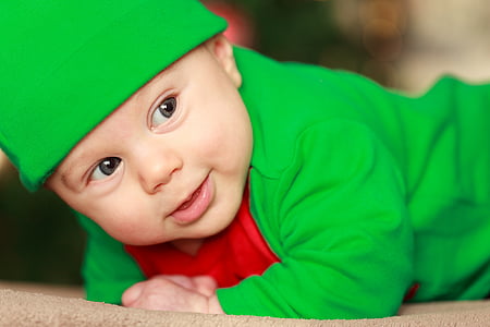 baby wearing green top and hat thumbnail
