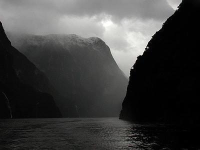 grayscale photograph of mountains near body of water thumbnail