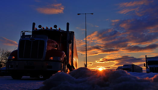 silhouette of trailer truck under cloudy sky thumbnail