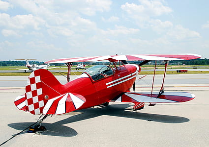 red and white monoplane during daytime thumbnail