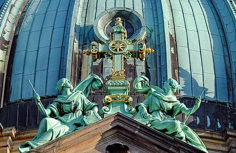 green man, woman, and cross statue during day thumbnail