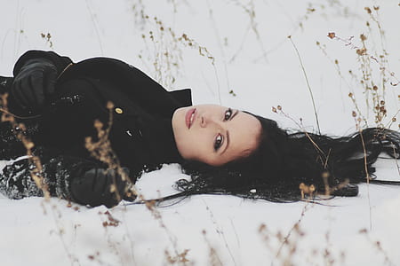 woman supine lying on snow surrounded by grasses thumbnail