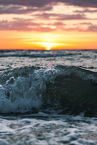 wave of body of water during golden hour thumbnail