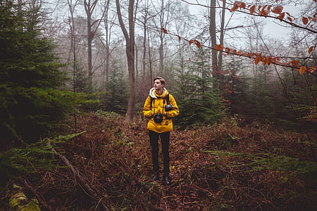 man holding camera while standing in the middle of grass thumbnail
