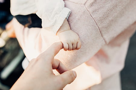 baby holding person's finger thumbnail