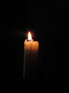 lighted candle in dark room thumbnail