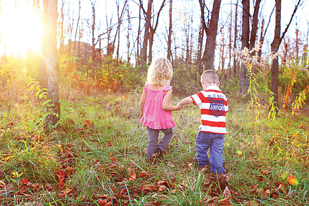 boy and girl walking on grass field thumbnail