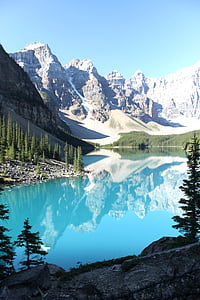calm body of water near the mountain covered with snow during daytime thumbnail