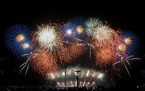 people standing while looking at the fire works display thumbnail