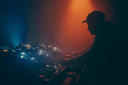 A DJ operating a music mixing console in a club thumbnail