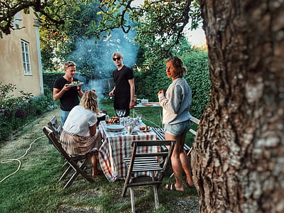 four person near table eating and standing thumbnail