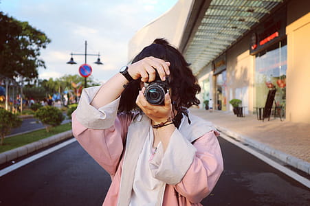 Woman Wearing Pink Coat Holding Dslr Camera thumbnail