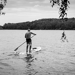 person riding on white paddle board on body of water thumbnail