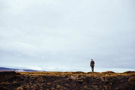 A young caucasian hiker stops near a rockey edge thumbnail