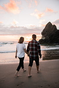Two Man and Woman Walking While Holding Hands Together thumbnail
