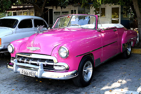 classic pink convertible coupe parked near white vehicle thumbnail