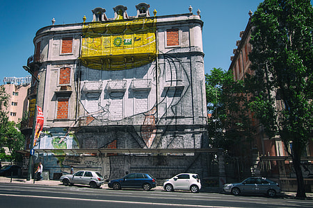Wide-angle street shot of a building covered in street art. Image captured in Lisbon, Portugal thumbnail
