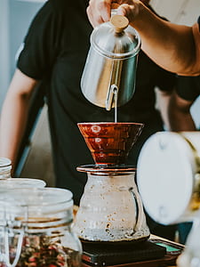 person pouring water on brown ceramic cup thumbnail
