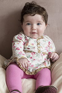 baby sitting on white chair thumbnail