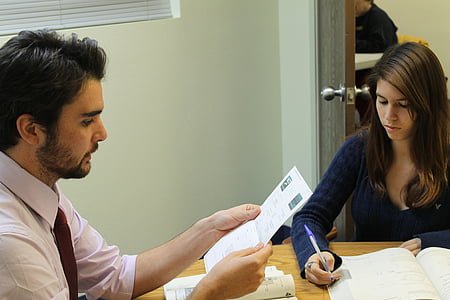 woman wearing blue top holding ballpoint pen thumbnail