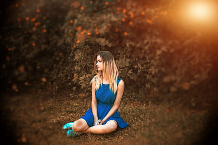 woman in blue sleeveless dress sitting on ground thumbnail