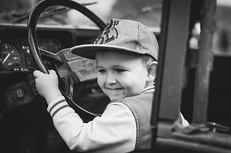grayscale photography of boy inside car thumbnail