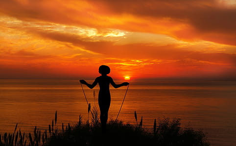Exercising with jump rope in the sunset. thumbnail