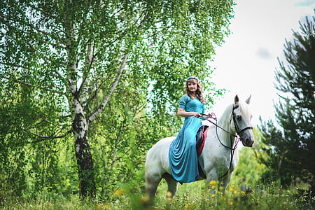 woman in blue dress riding on white horse thumbnail