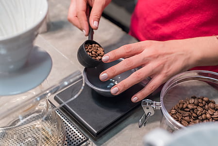 person pouring coffee beans on bowl thumbnail