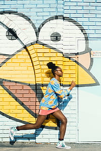 woman acting running position beside bird graffiti wall thumbnail