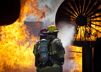fireman holding hose in front of fire thumbnail