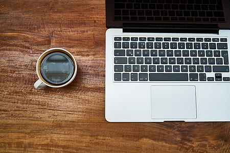coffee mug beside MacBook Pro thumbnail